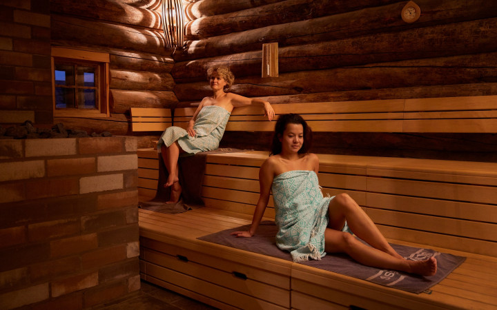 Gasten genieten van een opgieting bij de Bakhuys sauna van Zwaluwhoeve 